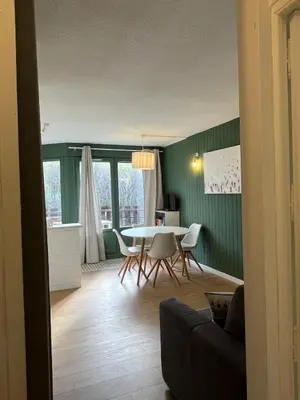 a dining room with a table and chairs in a room at Mignon petit Studio 25m2 avec balcon et Parking face départ pistes ! in Demi-Quartier