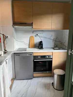 a small kitchen with a stove and a sink at Mignon petit Studio 25m2 avec balcon et Parking face départ pistes ! in Demi-Quartier