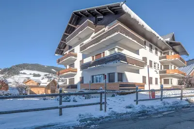a large building with snow on the ground at Appartement Hermine - Welkeys in Megève