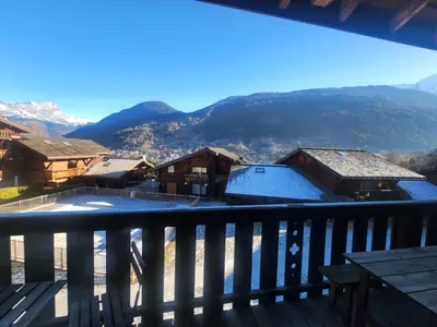 a chair on a balcony with a view of mountains at Au coeur des Alpes in Saint-Gervais-les-Bains