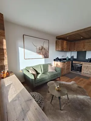 a living room with a green couch and a table at Le green d'Arbois - Ski au pied in Megève