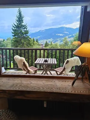 a balcony with a table and two stuffed animals at Le green d'Arbois - Ski au pied in Megève