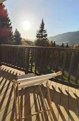 a wooden bench sitting on top of a deck at Le green d'Arbois - Ski au pied in Megève