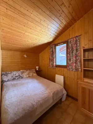a bedroom with a bed in a wooden cabin at Au cœur des pistes in Saint-Gervais-les-Bains