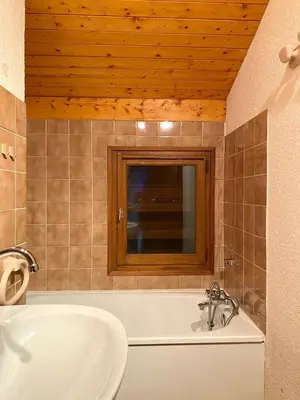a bathroom with a tub and a sink and a mirror at Au cœur des pistes in Saint-Gervais-les-Bains