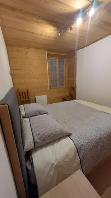 a bedroom with a bed in a wooden cabin at L'Helvetia in Chamonix-Mont-Blanc
