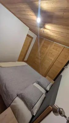 a bed in a room with a wooden ceiling at L'Helvetia in Chamonix-Mont-Blanc