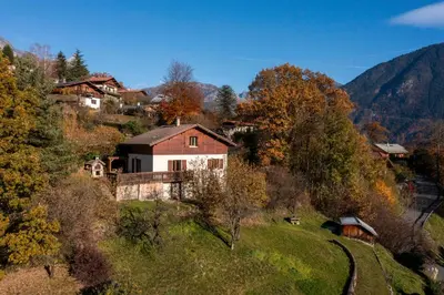 a house on top of a hill with trees at Chalet 8 personnes in Passy