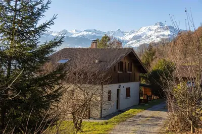 a house with snowy mountains in the background at Studio 2 personnes in Passy