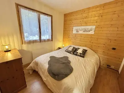a bedroom with a bed in a wooden wall at Charmant appartement 3 pièces, jardin, parking et wifi à Demi-Quartier - FR-1-597-187 in Demi-Quartier