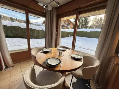 a table and chairs in a room with a large window at Charmant appartement 3 pièces, jardin, parking et wifi à Demi-Quartier - FR-1-597-187 in Demi-Quartier