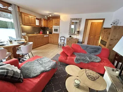 a living room with two red couches and a kitchen at Charmant appartement 3 pièces, jardin, parking et wifi à Demi-Quartier - FR-1-597-187 in Demi-Quartier