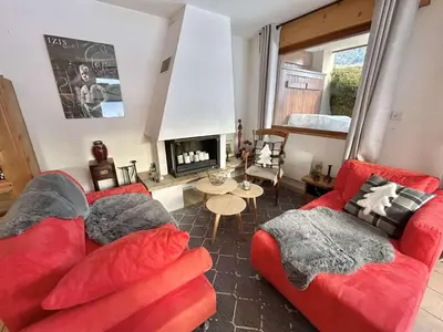 a living room with two red couches and a fireplace at Charmant appartement 3 pièces, jardin, parking et wifi à Demi-Quartier - FR-1-597-187 in Demi-Quartier