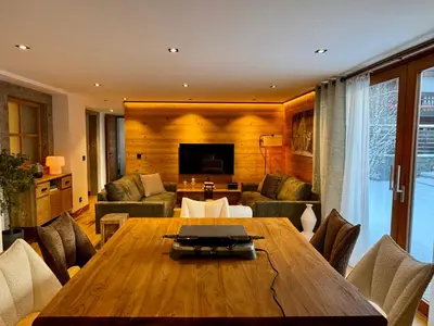 a living room with a wooden table and a couch at Woodpecker Appartement au coeur du village in Les Houches