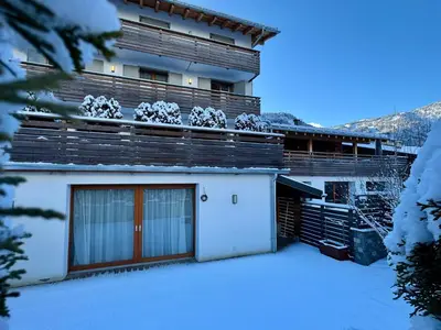 a building with snow on the ground in front of it at Woodpecker Appartement au coeur du village in Les Houches
