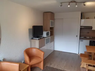 a small living room with a television and a kitchen at Joli studio aux Carroz d'Arâches in Arâches-la-Frasse