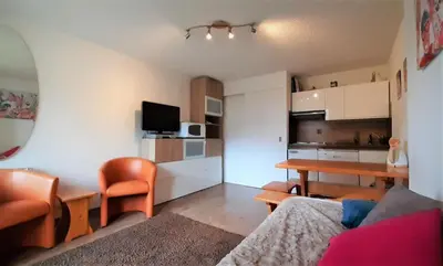 a living room with a table and a dining room at Joli studio aux Carroz d'Arâches in Arâches-la-Frasse