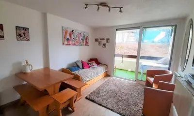 a living room with a table and a couch at Joli studio aux Carroz d'Arâches in Arâches-la-Frasse