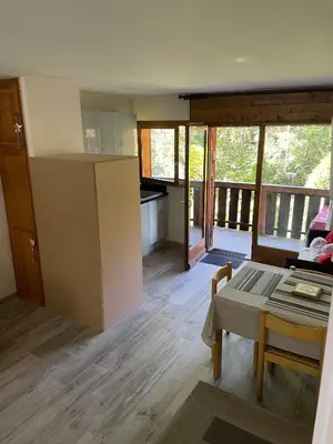 a kitchen and living room with a table and a room at Grand studio Combloux - Vue Mont Blanc in Combloux