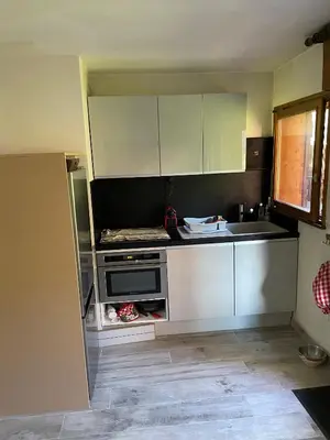 a kitchen with white cabinets and a sink at Grand studio Combloux - Vue Mont Blanc in Combloux