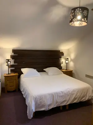 a bedroom with a large white bed and a chandelier at Les fermes de saint gervais in Saint-Gervais-les-Bains