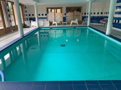 a large swimming pool with blue water at Les fermes de saint gervais in Saint-Gervais-les-Bains