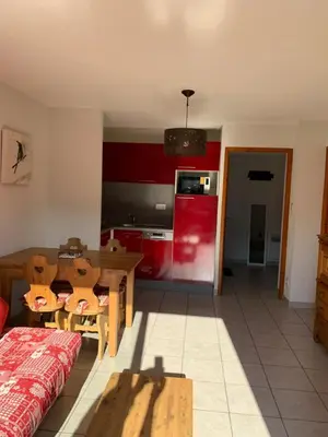 a kitchen with a table and a red refrigerator at Les fermes de saint gervais in Saint-Gervais-les-Bains