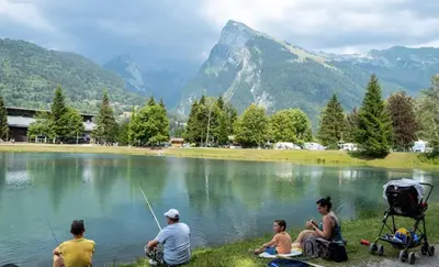 a group of people sitting around a lake fishing at Le Refuge, Mobil Home 3 rooms avec Climatisation in Samoëns