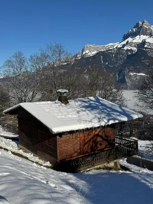 a log cabin in the snow with a mountain at Charmant petit chalet cosy in Combloux