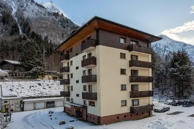 a building with balconies and snow on the ground at Les Trois Balcons Apartment - Chamonix All Year in Chamonix-Mont-Blanc