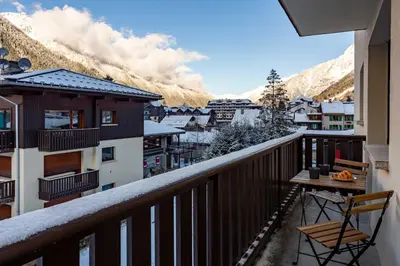 a balcony with a table and a view of the mountains at Les Trois Balcons Apartment - Chamonix All Year in Chamonix-Mont-Blanc