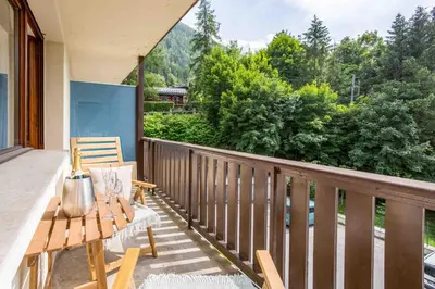 a balcony with a wooden bench and a table at Les Trois Balcons Apartment - Chamonix All Year in Chamonix-Mont-Blanc