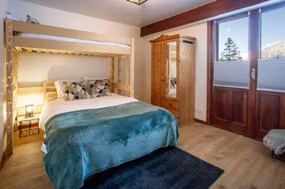 a bedroom with a large bed and a large window at Les Trois Balcons Apartment - Chamonix All Year in Chamonix-Mont-Blanc