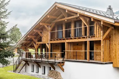 a large timber house with a large deck at MEGEVE Chalet d'architecte pour 16 personnes in Megève