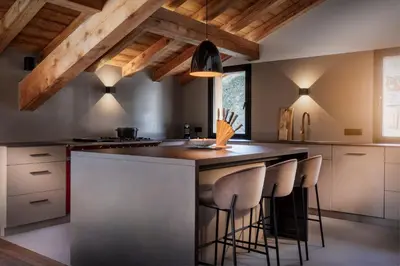 a kitchen with a large island with bar stools at MEGEVE Chalet d'architecte pour 16 personnes in Megève