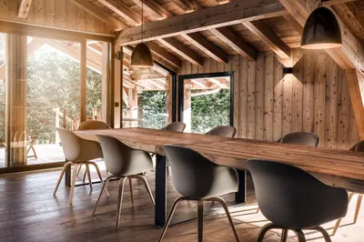 a dining room with a wooden table and chairs at MEGEVE Chalet d'architecte pour 16 personnes in Megève