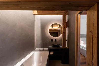 a bathroom with a bath tub and a mirror at MEGEVE Chalet d'architecte pour 16 personnes in Megève