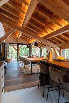 a dining room with wooden ceilings and a table and chairs at MEGEVE Chalet d'architecte pour 16 personnes in Megève