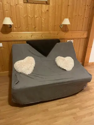 a bed with two heart shaped pillows on it at Appartement 4 personnes in Combloux