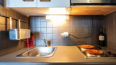 a kitchen counter with a sink and a bottle of wine at Grande Neige N 33 - 2P5 in Morillon