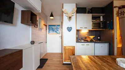 a kitchen with white cabinets and a deer head on the wall at Grande Neige N 33 - 2P5 in Morillon