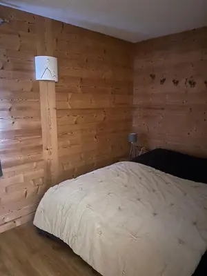 a bedroom with a bed in a wooden wall at Carroz d Araches , 2 pièces rénové vue montagne, 4 personnes, 3 min du centre, parking,balcon in Arâches-la-Frasse