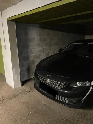 a black car is parked under a garage at Carroz d Araches , 2 pièces rénové vue montagne, 4 personnes, 3 min du centre, parking,balcon in Arâches-la-Frasse