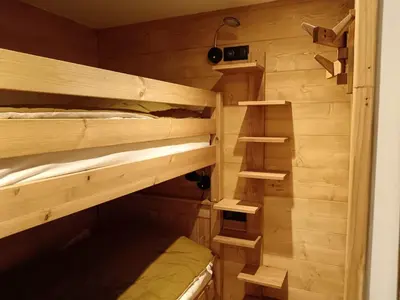 a room with two bunk beds with wooden walls at Karibu in Saint-Gervais-les-Bains