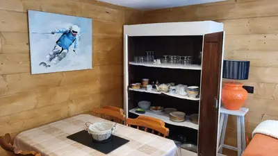 a room with a table and a picture of a skier at Karibu in Saint-Gervais-les-Bains