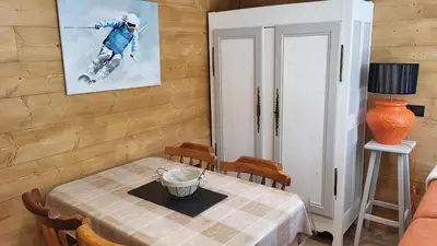 a dining room with a table and a picture of a skier at Karibu in Saint-Gervais-les-Bains