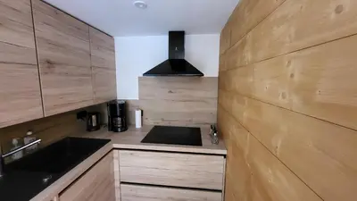 a kitchen with wooden cabinets and a sink and a stove at Karibu in Saint-Gervais-les-Bains