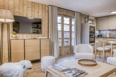 a living room with a table and a kitchen at Écrin de raffinement au cœur de Megève in Megève