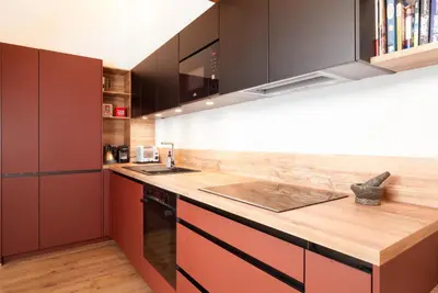 a kitchen with red cabinets and a wooden counter top at The Loft in Saint-Gervais-les-Bains