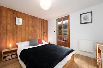 a bedroom with a large bed and wooden walls at The Loft in Saint-Gervais-les-Bains